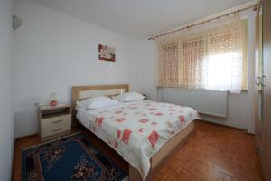a bedroom with a bed and a window at Apartman Pero in Kikinda