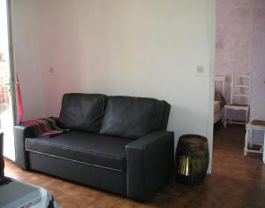 a black leather couch sitting in a living room at GITE MAMIE LAURENCE in Gruissan