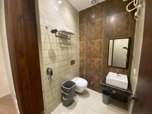 卢迪亚纳Hotel The Retro Regency的带水槽、马桶和镜子的浴室