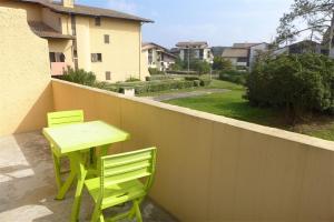 two green chairs and a table on a balcony at Réf 546, Seignosse océan , Appartement classé 2 étoiles , plage et centre à 5mn, 5 personnes in Seignosse