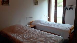 two beds in a room with a window at Réf 259, Seignosse océan, Villa Patio au calme, plage et commerces à proximité, 6 personnes in Seignosse