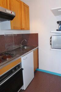 a small kitchen with a sink and a stove at Réf 546, Seignosse océan , Appartement classé 2 étoiles , plage et centre à 5mn, 5 personnes in Seignosse