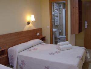 a bedroom with two beds with towels on them at Hostal Sant Sadurní in Sant Sadurní dʼAnoia
