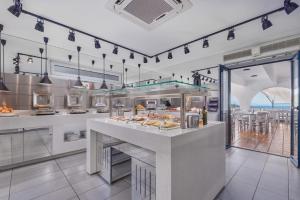 a restaurant kitchen with a counter with food at Adrina Beach Hotel in Panormos Skopelos