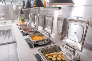 a kitchen with several trays of food on a counter at Adrina Beach Hotel in Panormos Skopelos