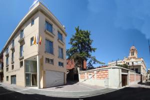 a large white building on the corner of a street at Hostal Sant Sadurní in Sant Sadurní dʼAnoia