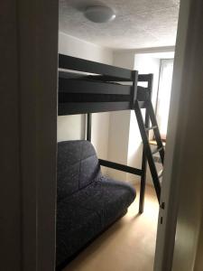 a bunk bed in a room with a chair underneath it at Joli appartement à Murat proche du Lioran Cantal in Murat