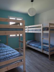 a room with two bunk beds and a lamp at Maison Bassin d'Arcachon - Arès - Proche plage et commerces, 3 chambres, 8 personnes, Climatisation in Arès