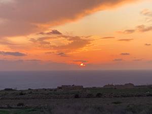 a sunset over the ocean with the sun in the sky at Fiftyfour West Boutique Living in Għarb