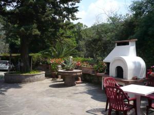a patio with a fireplace and tables and chairs at Casolare con Piscina al mare in Castagneto Carducci