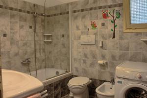 a bathroom with a shower toilet and a sink at Casolare con Piscina al mare in Castagneto Carducci