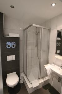 a bathroom with a shower and a toilet and a sink at Centro Hotel Oberhausen in Oberhausen