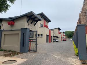 a row of houses on a street with a gate at 66 Dorp Street Apartment in Polokwane