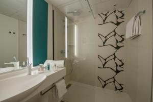 a white bathroom with a sink and a shower at Thalazur Arcachon in Arcachon