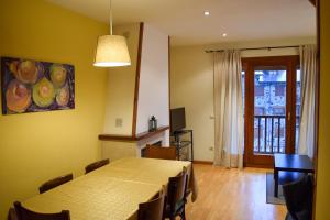 a dining room with a table and chairs and a window at Duplex con vistas en Benasque in Benasque