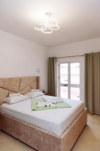 a bedroom with a large white bed and a window at Mala Plaza in Ulcinj