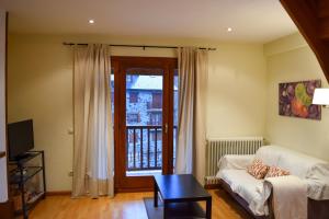 a living room with a couch and a window at Duplex con vistas en Benasque in Benasque