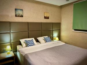a bedroom with a large bed with blue and white pillows at Hotel Vzlet in Orenburg