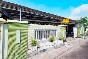 a green and white building with potted plants on it at Griya Sakura Syariah in Solo