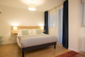 a bedroom with a bed and a large window at Lolig in Honfleur