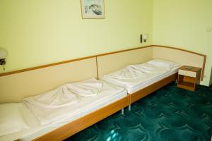 two twin beds in a room with a table at Struma Hotel in Pernik