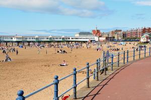 a group of people on the beach near a pier at Seaside Loft in Lytham St Annes