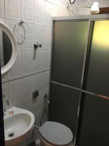 a bathroom with a shower and a toilet and a sink at Pousada Pepalantus in Serra do Cipo