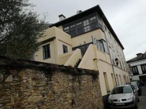 a building with a car parked in front of it at NAMOR-Apartamento Tres Balcones in Ribadeo