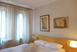 a bedroom with a bed with white pillows and a window at Villa Quantum Beograd in Belgrade