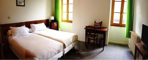 a bedroom with a bed and a desk and window at Le Prieuré in Saint-Dalmas-de-Tende