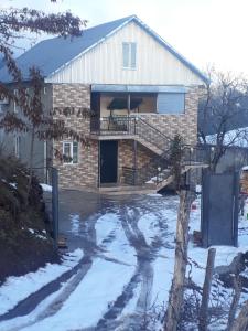 una casa in mattoni con un portico nella neve di Guest House Karati a Khulo