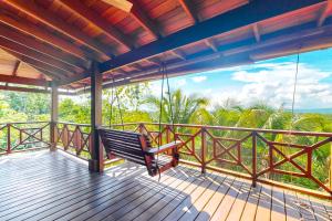 a porch with a swinging bench on a balcony at Divina @ Framadani Estate in San Ignacio