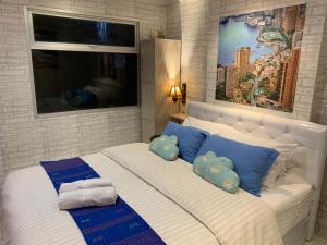 een slaapkamer met een groot bed met blauwe kussens bij WOLKE Bellevue comfort Apartment in Bandung