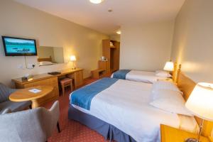 a hotel room with two beds and a television at Cromore Halt in Portstewart