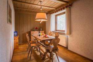 una sala da pranzo con tavolo e sedie in legno di RESIDENCE ALICE NEL PAESE DELL' ARMENTAROLA a San Cassiano