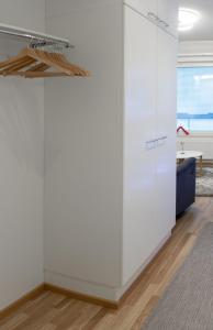 ロヴァニエミにあるApartment Laura A6の白い壁の客室で、青いソファが備わります。