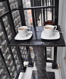 twee kopjes koffie op een tafel op een balkon bij WOLKE Bellevue comfort Apartment in Bandung