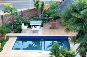a garden with a swimming pool and plants at @Home in the East in Pretoria