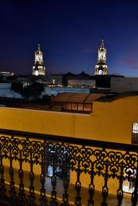 a view of two towers at night from a balcony at Hostal Los Balcones de Moral y Santa Catalina in Arequipa