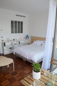 - une chambre avec un lit blanc et du parquet dans l'établissement Appartement design avec terrasse, à Paris