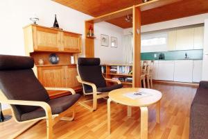 a living room with a table and chairs and a kitchen at Tgesa Sunnmatt Nr. 13 in Savognin