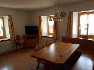 ein Wohnzimmer mit einem Holztisch und einem TV in der Unterkunft Tga Mucki in Savognin