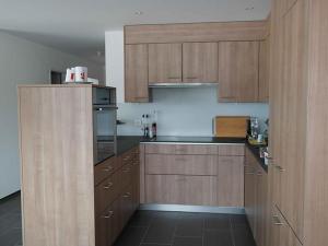 a kitchen with wooden cabinets and a counter top at Sandeilas 10 in Savognin