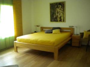 a bedroom with a yellow bed and a window at Canetel 11 Whg 3 in Savognin
