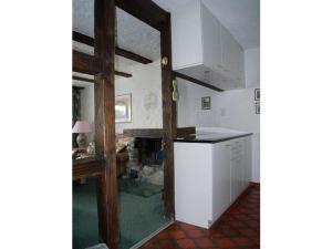 a kitchen with white cabinets and a fireplace at Haus Viols 54 in Savognin