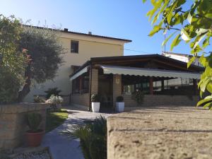 a house with a porch and a building at Pit Lane AFFITTACAMERE in Offida