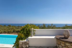 a white tub sitting next to a swimming pool at Kostas Cottages in Agios Nikolaos