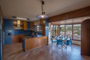 een keuken met een tafel en stoelen en een keuken met blauwe muren bij Villa Othelo in Ayia Napa