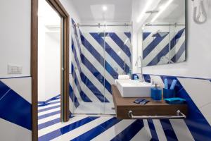 a bathroom with a blue and white striped wall at Aquae Romanae Piazza Lauro in Sorrento +65 photos