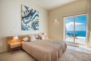 Un dormitorio con una cama y vista al mar. en Villa La Terrasse Palheiro Village with private pool by HR Madeira, en São Gonçalo